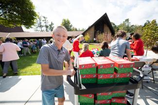 Youth with shoebox gifts on trolley