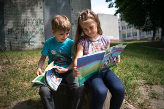 Boy and girl in Ukraine reading The Greatest Journey book