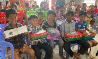 Boys smiling with shoebox in hand.