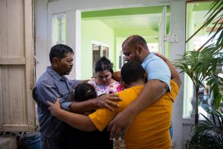 Pastor Rigoberto Mejia (left) prays with the Peña family, who placed their faith in Jesus Christ after their children received Operation Christmas Child shoebox gifts at Key Baptist Church in El Cayo, Honduras.
