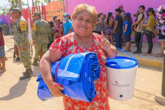 A resident is Acapulco is grateful for the tarpaulin and the bucket she received from Samaritan’s Purse.