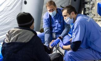 Paramedics assess the feet of an injured man