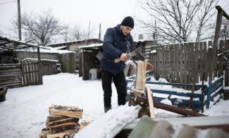 Ukrainian man cutting firewood