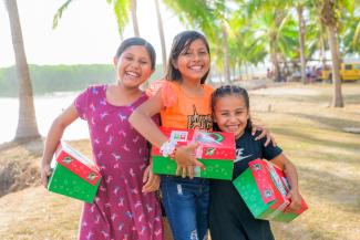 Children smiling with their OCC shoebox in hand