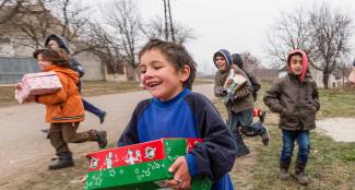 children running with shoebox gifts