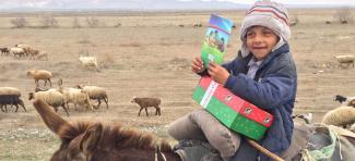 boy on a donkey holding shoebox gift