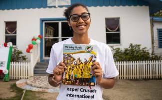 Lashon smiles for the camera with a Ministry Guide in hand