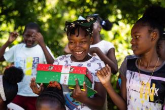 A GIRL IN SAINT ANDREW PARISH SMILES AFTER RECEIVING HER SHOEBOX GIFT.