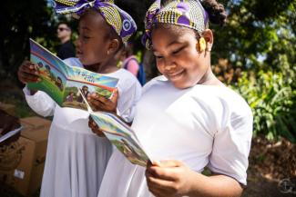 GIRLS IN GRENADA READ THE GREATEST GIFT GOSPEL BOOKLET THEY RECEIVED WITH THEIR GIFT-FILLED SHOEBOX.