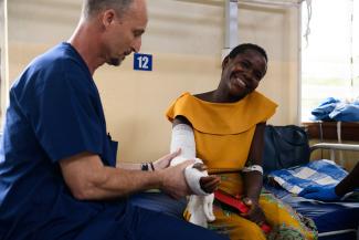 KEMP LAIDLEY, A PHYSICAL THERAPIST WITH SAMARITAN’S PURSE, HELPS IREEN AFTER HER SURGERY. DESPITE THE PAIN, IREEN STILL SMILES.