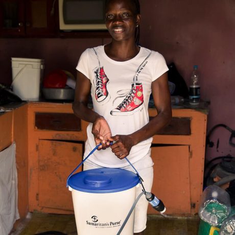 SIMONE SHOWS OFF HER HOUSEHOLD WATER FILTER SUPPLIED BY SAMARITAN’S PURSE.