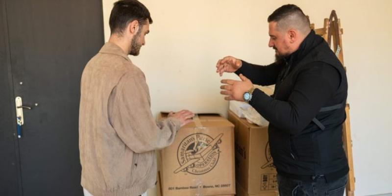 AKAKI (LEFT) AND PASTOR PAATA PREPARE TO DISTRIBUTE SHOEBOX GIFTS TO DEAF CHILDREN.