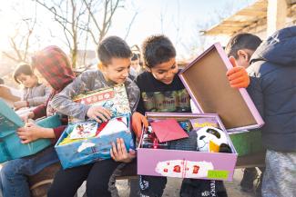 Children smiling with their OCC shoebox in hand