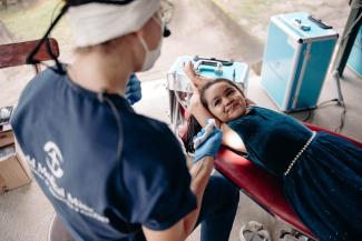 Between patients, Marya, the team’s dental hygienist, allows a curious young girl to try the dental chair and teaches her how to brush her teeth.