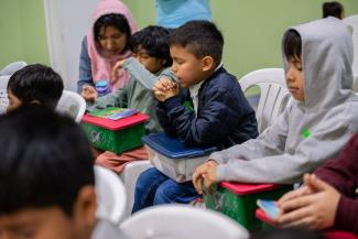 Children and their families pause to pray before opening their Operation Christmas Child shoebox gifts.