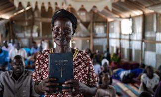 Elizabeth holds the Word of God, which she can now read and teach from after learning to read in the Nuer language in our church-based literacy programme.