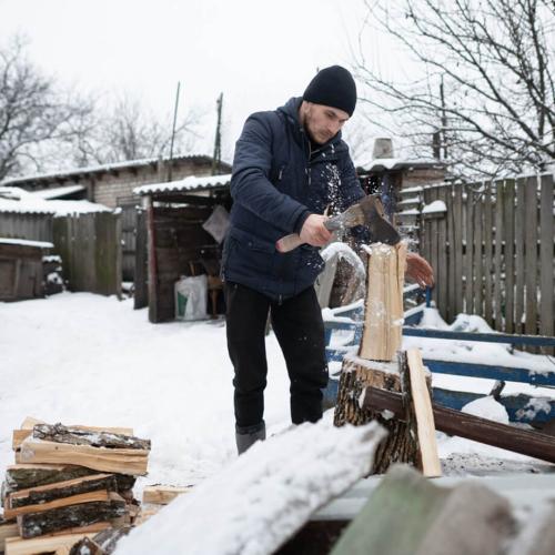 Ukrainian man cutting firewood